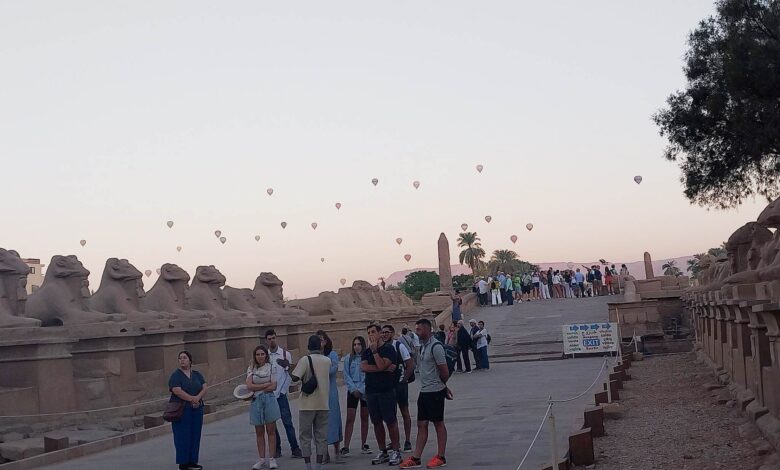 صورة اليوم.. سياح العالم يستمتعون بزيارة معابد الكرنك مع تحليق رحلات البالون الطائر